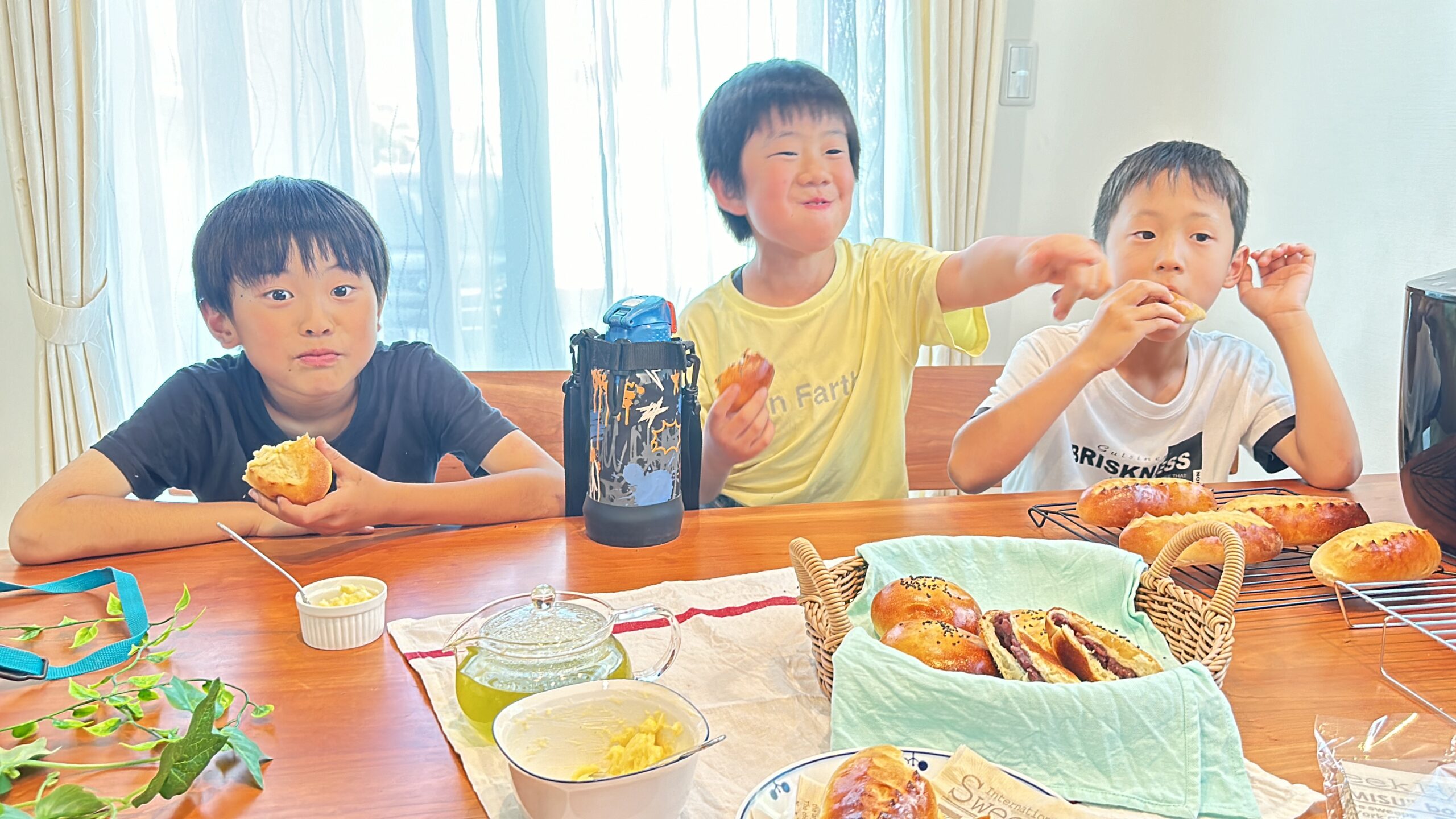 楽しそうにパンを食べる男の子３人