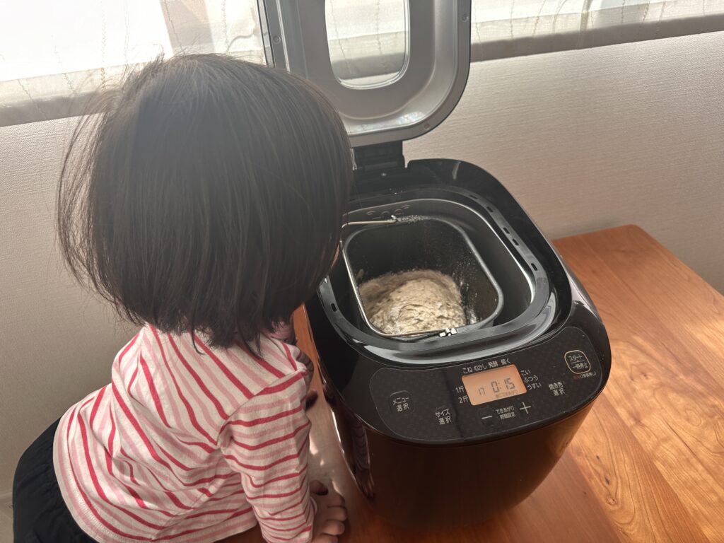 ホームベーカリーの中を覗き込む子供