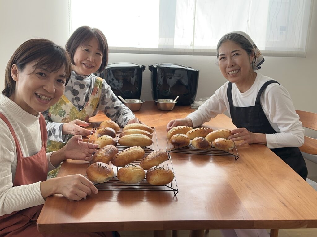 焼き上がったあんぱんとピコパン、笑顔の生徒様お二人と講師