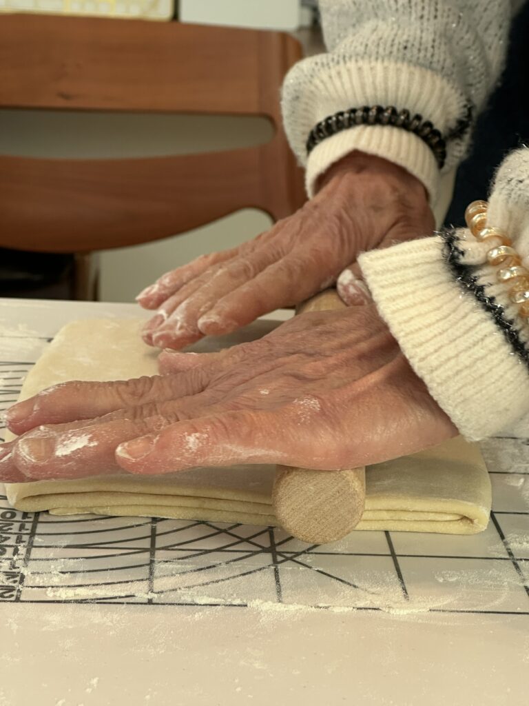 クロワッサン生地をめん棒で伸ばしている