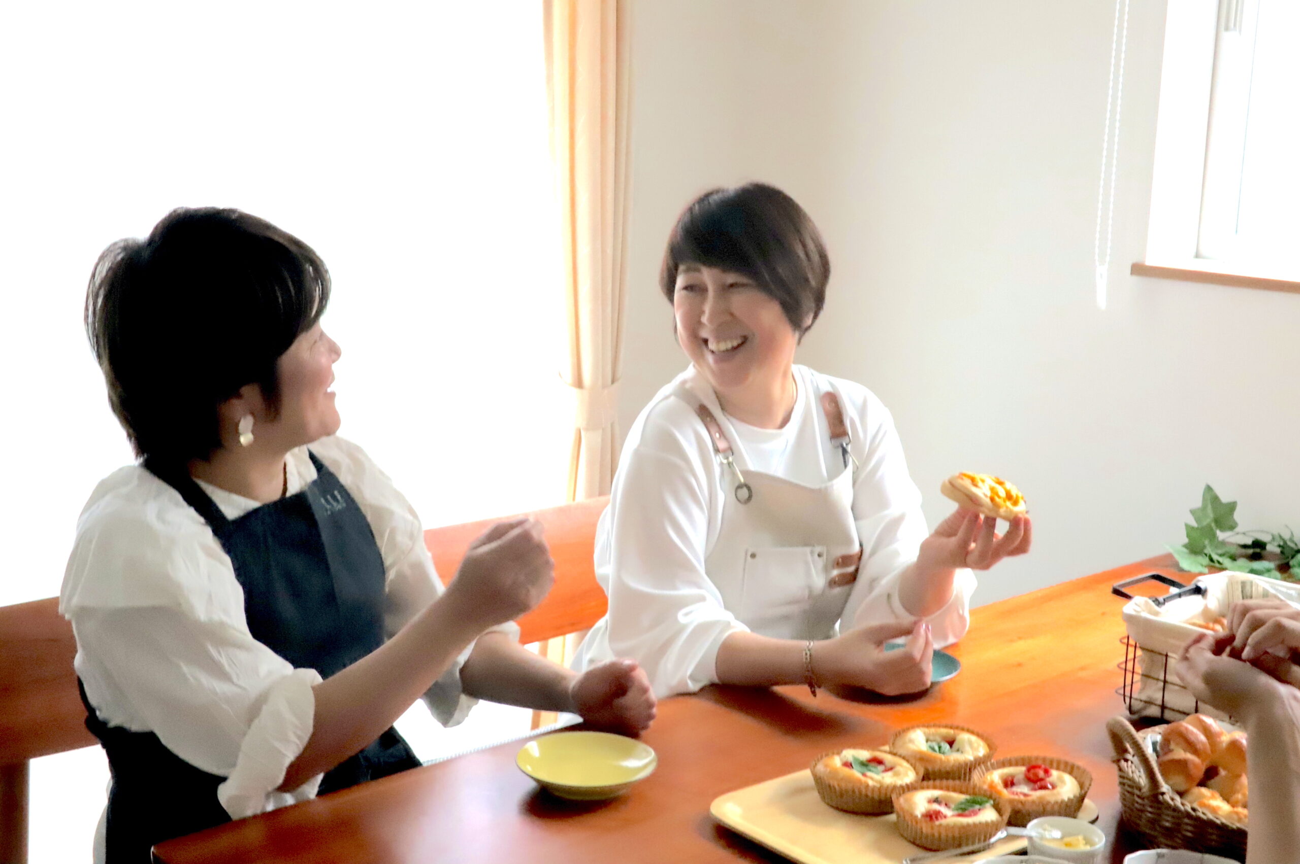 パンを二人の女性が笑顔で食べている