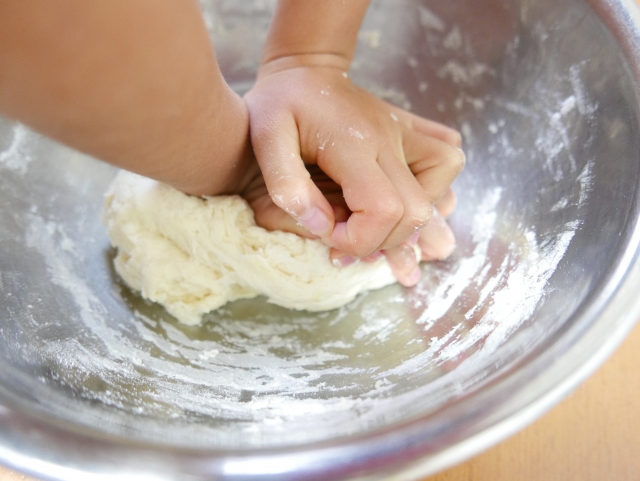 パン生地をこねている子供の手